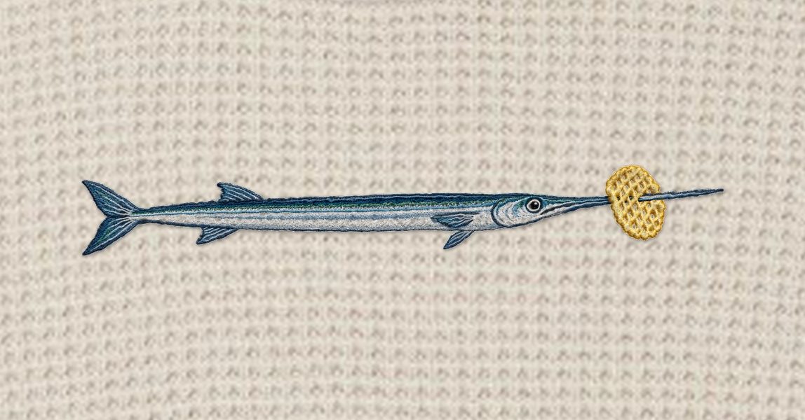 Close-up of the embroidered needlefish with a golden lattice crisp on its beak, stitched into waffle knit